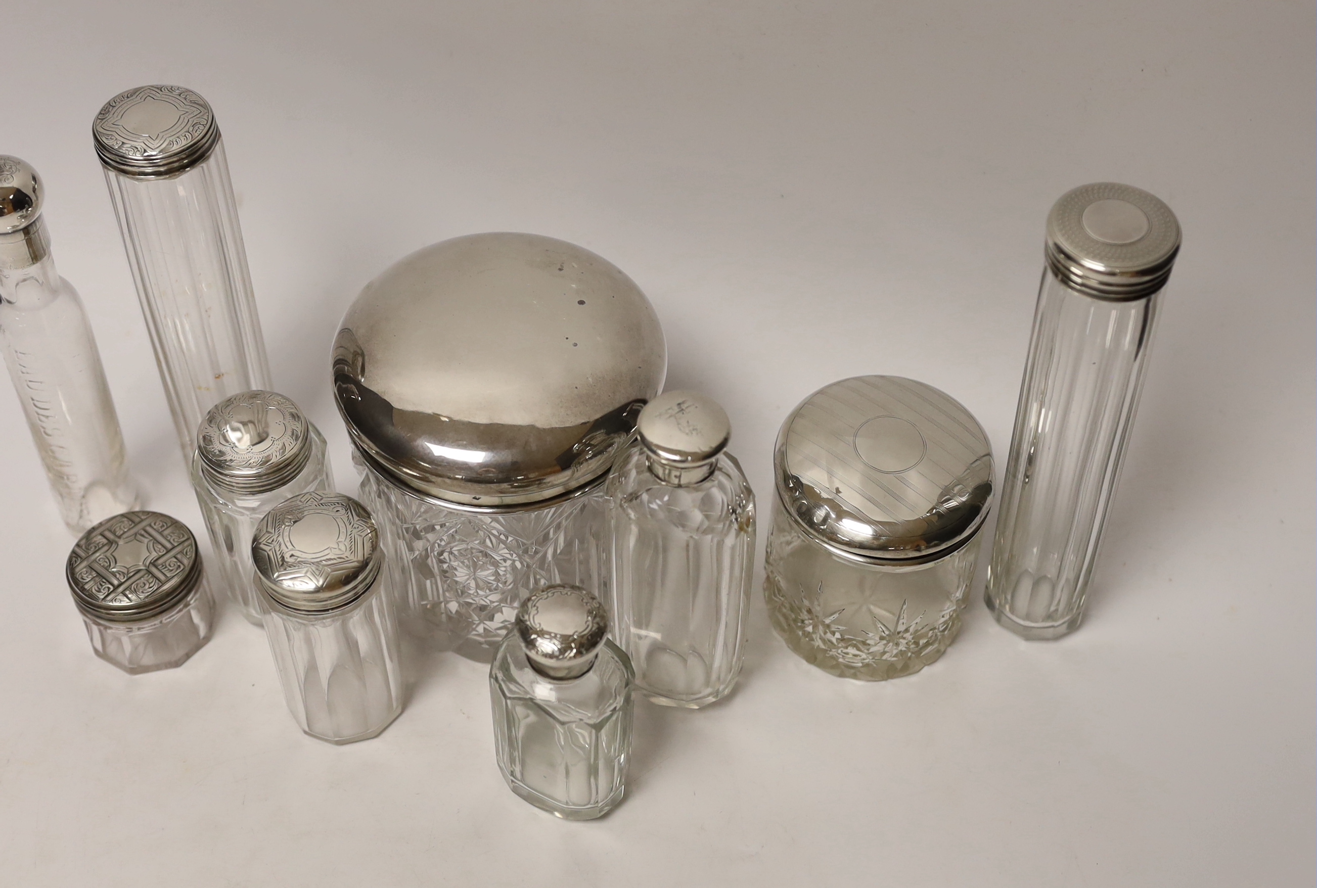 A group of assorted silver or white metal topped toilet jars, tallest 17.6cm.